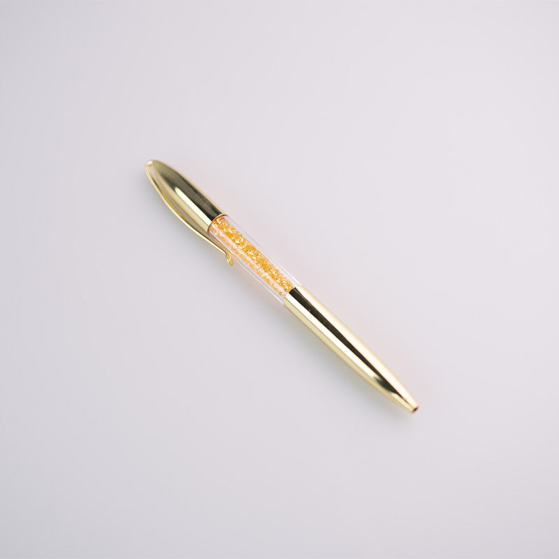 Penna con dettagli in oro ed inchiostro nero in due varianti: con diamantini in oro e diamantini in rosso.