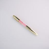 Penna con dettagli in oro ed inchiostro nero in due varianti: con diamantini in oro e diamantini in rosso.